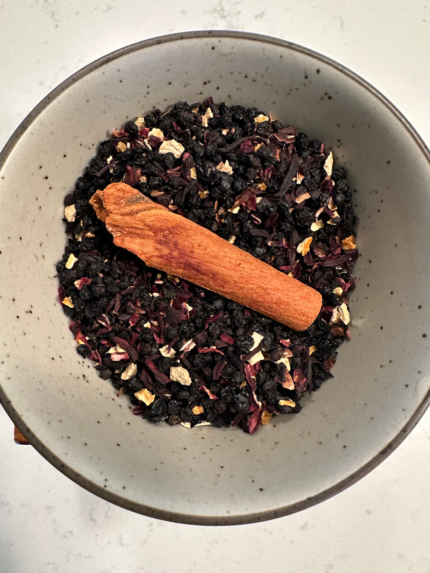 Hibiscus + Elderberry botanical tea blend in a ceramic bowl